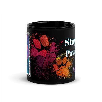 Stay Pawsitive text with image of a Beagle dog on stained glass style background with colorful paw prints on a black ceramic mug 11 oz — front view