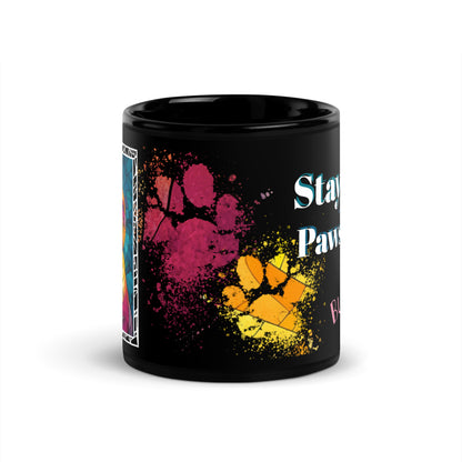 Stay Pawsitive text with image of a Bulldog on stained glass style background with colorful paw prints on a black ceramic mug 11 oz — front view