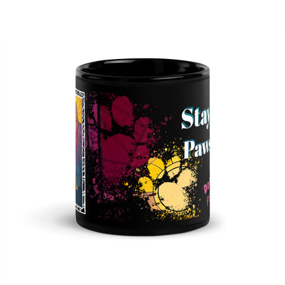 Stay Pawsitive text with image of a Doberman Pinscher dog on stained glass style background with colorful paw prints on a black ceramic mug 11 oz — front view