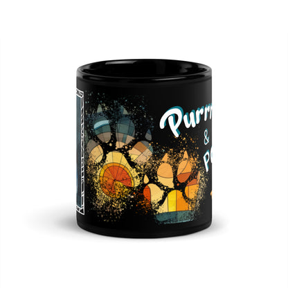 Purrr & Pour text with image of a Tuxedo cat on stained glass style background with colorful paw prints on a black ceramic mug 11 oz — front view