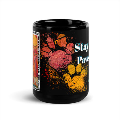 Stay Pawsitive text with image of a Pomeranian dog on stained glass style background with colorful paw prints on a black ceramic mug 15 oz — front view